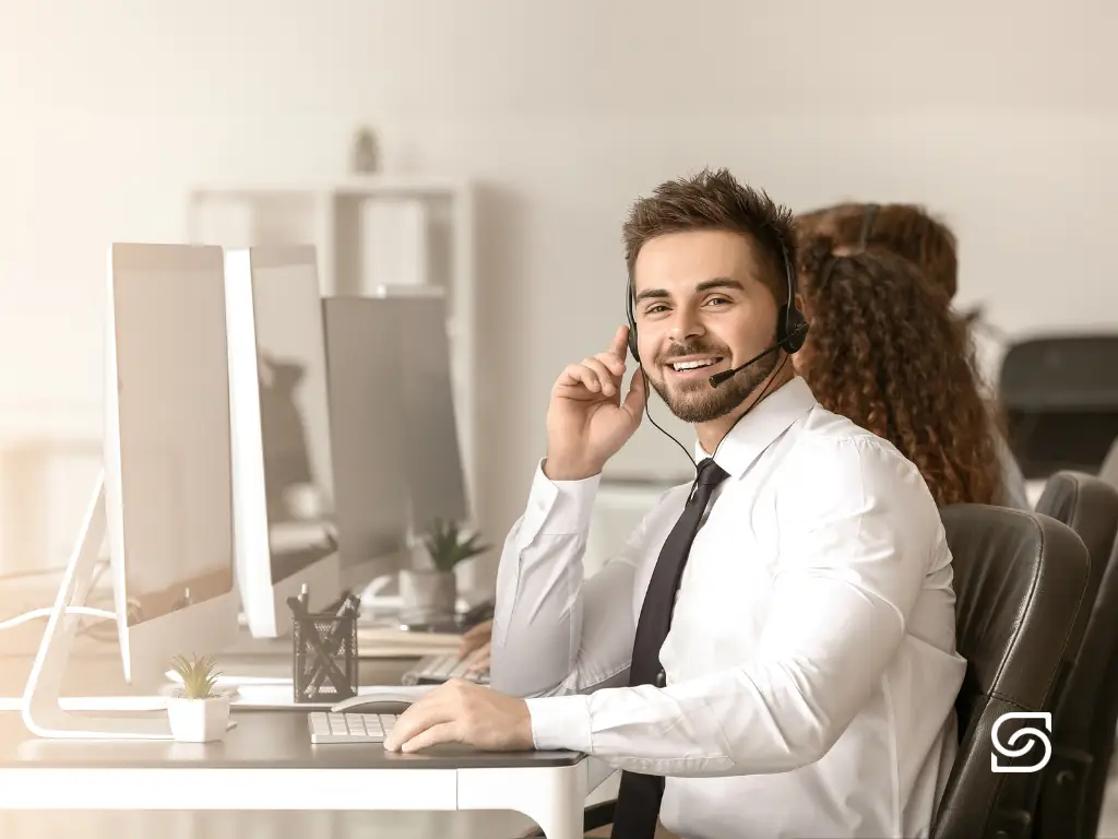 IT support representative working at a desk in a professional office environment.