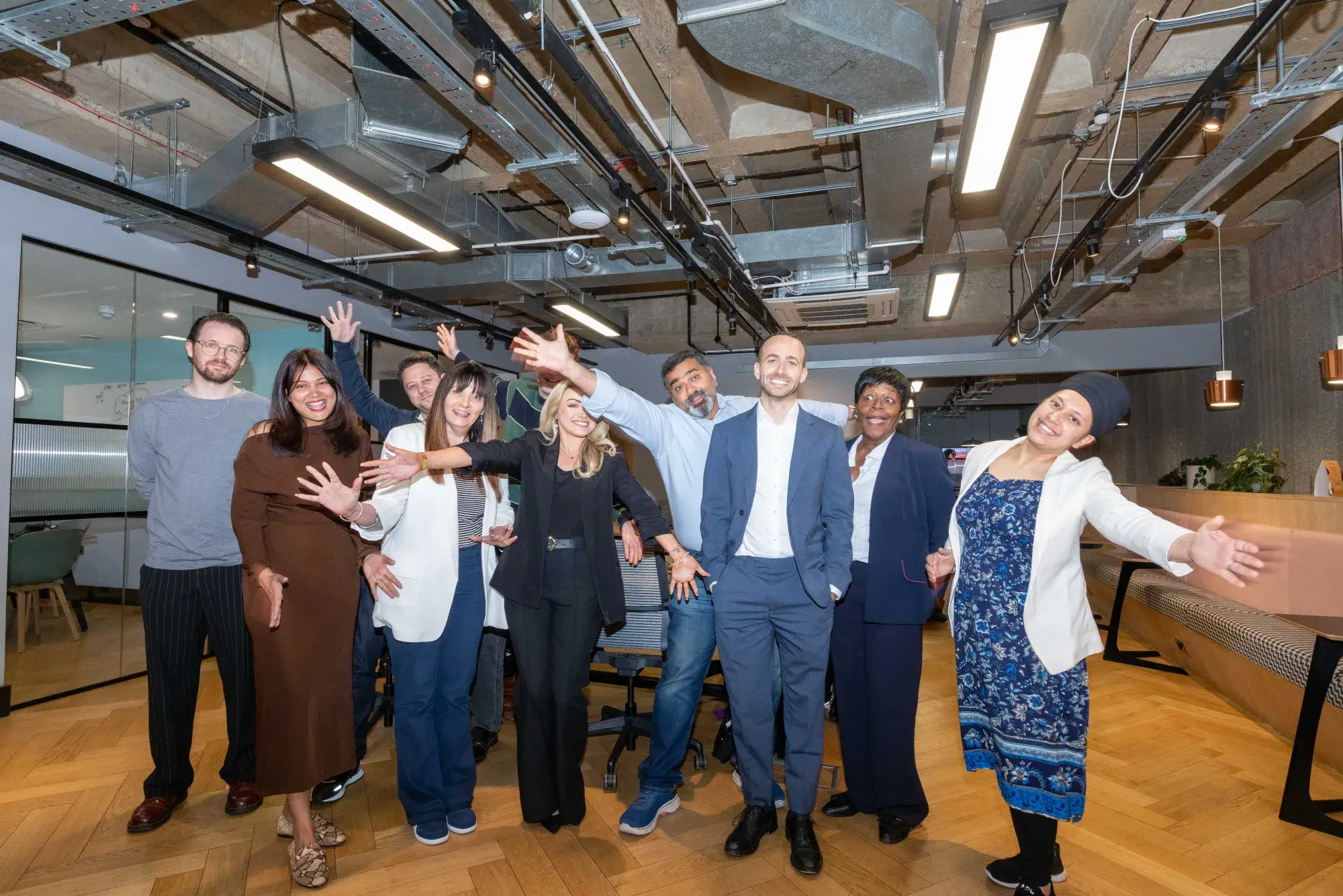 The Sereno IT team together in their London office, arms raised