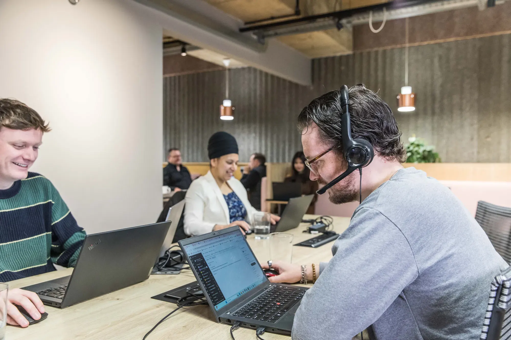 A Sereno support engineer wearing a headset resolving a client issue at a laptop